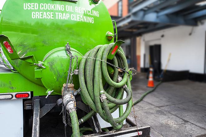 a grease trap being pumped by a sanitation technician in North Miami FL